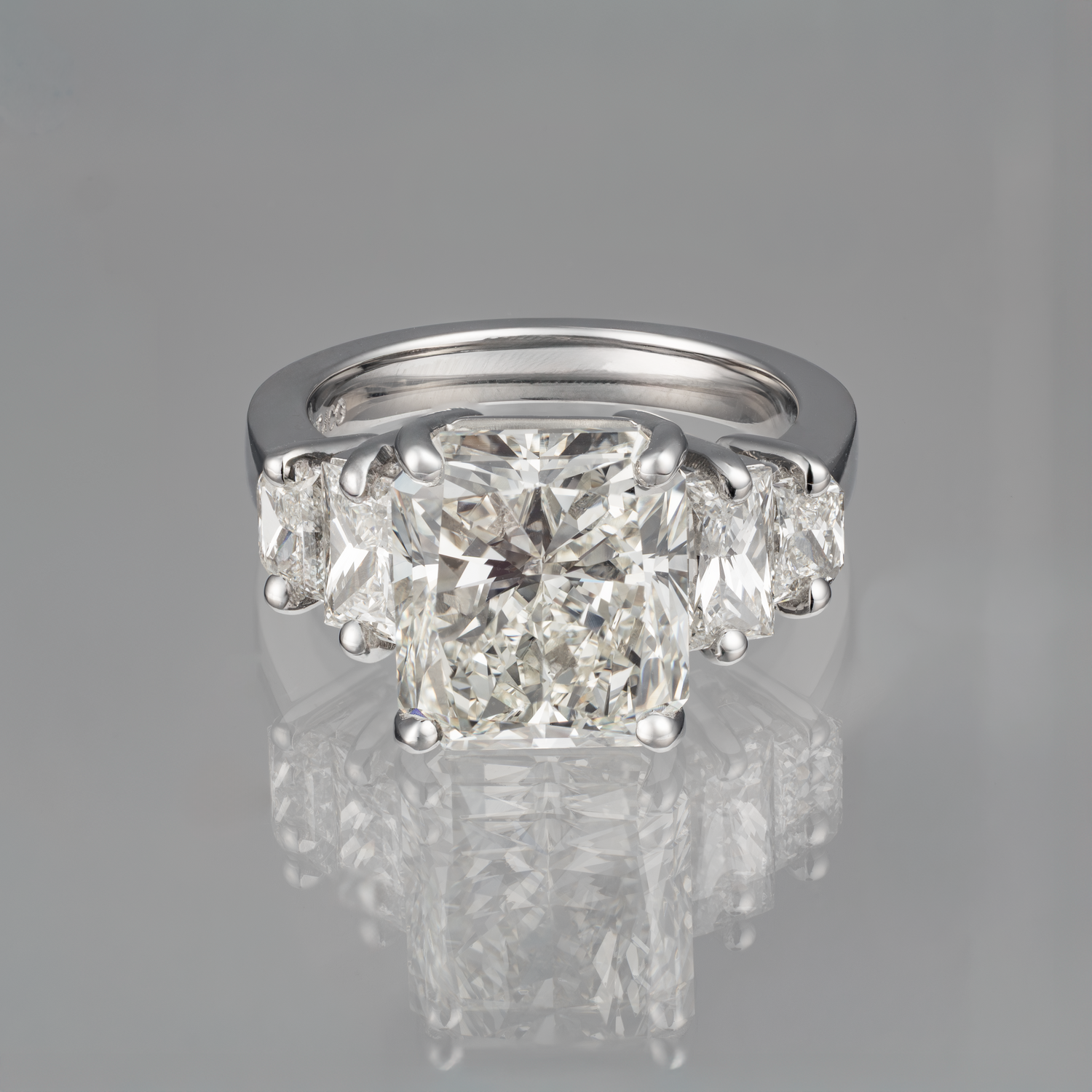 Diamond ring with three large diamonds on a gray background