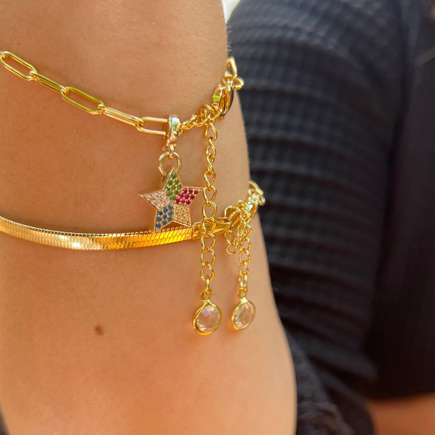Gold star charm on a person's Wrist.